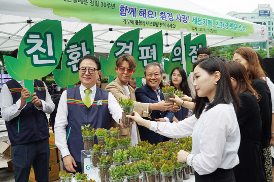 10일 서울 청계광장에서 정승인 코리아세븐 대표(왼쪽 첫번째부터)와 가수 토니안, 최열 환경재단 이사장 등 관계자들이 일회용 무지컵 화분을 들고 기념촬영을 하고 있다. <세븐일레븐 제공>